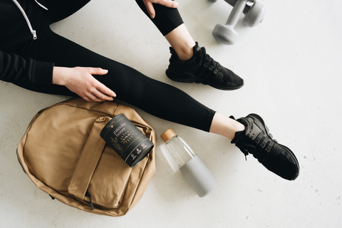 Lady with her gym bag, weights, water bottle and on-the-go Manuka honey sticks