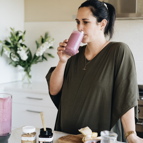 A women adding Manuka Honey 15+to her smoothie to add boosted happiness 