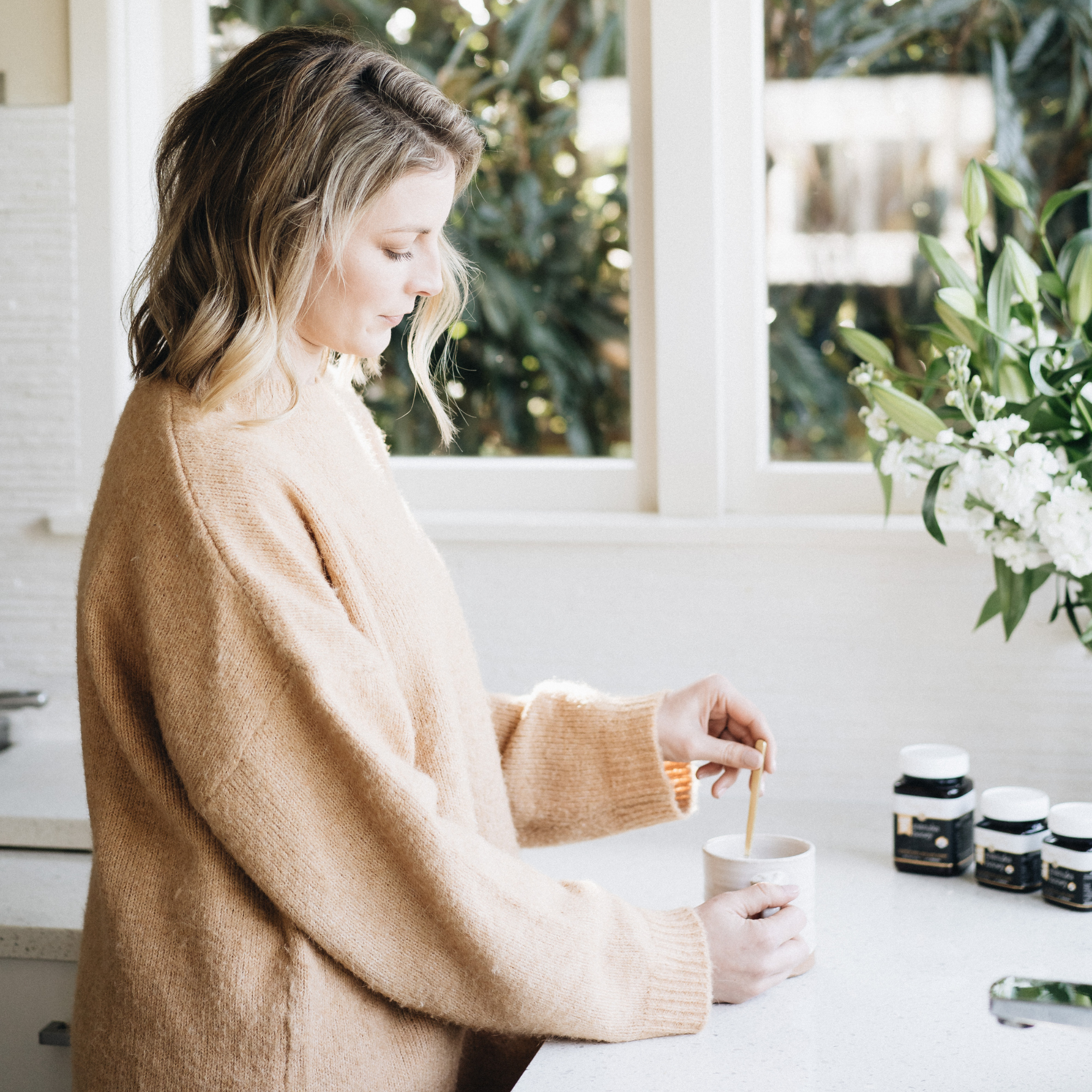 Women adding her UMF 10+ MGO 263+ Manuka Honey everyday to her morning drink