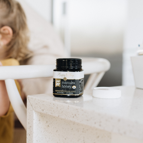 UMF 20+ MGo 829 Jar of Manuka honey on the kitchen bench alongside the first aid box being used on little girl to help treat skin problems